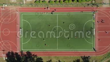 空中足球比赛。 两支球队在户外踢足球，俯视图。 户外足球比赛，绿色球场